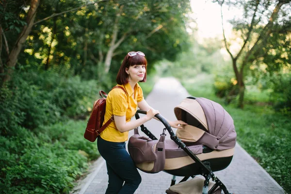 Νεαρή Μητέρα Περπατώντας Μωρό Μεταφορά Στο Πάρκο Βράδυ Ήλιο Λάμπει — Φωτογραφία Αρχείου