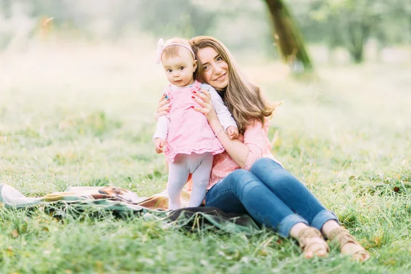 公園で幸せな母親と娘 家族のアウトドアライフスタイルと美容自然シーン 幸せな家族が一緒に緑の芝生の上で 楽しい屋外が休んでいる 家庭生活における幸福と調和 — ストック写真