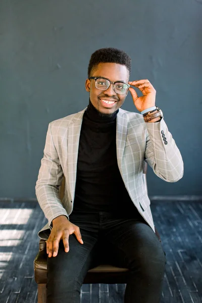 スタイリッシュなスーツと暗い背景に眼鏡でアフリカ系アメリカ人ビジネスの男性の肖像画を分離した陽気な笑顔 — ストック写真