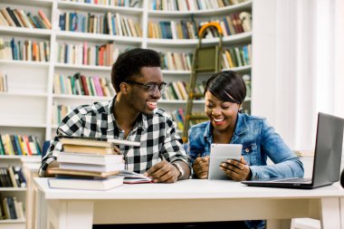 Mutlu Afro-Amerikan arkadaşlar Kütüphane masada otururken dizüstü bilgisayar kullanarak. Grup çalışma odasında Üniversitesi Kütüphanesi.