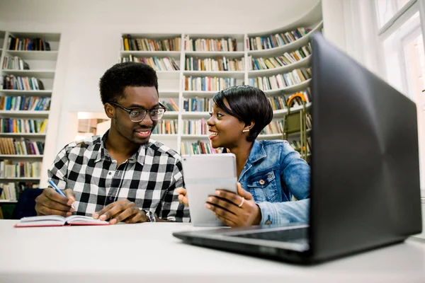 大学図書館での割り当てとの協力でアフリカ系アメリカ人学生 読書のテーブルに座っている若い人たちのグループ — ストック写真