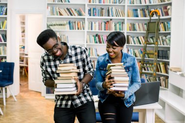 Gülümseyen ve Kitaplar tutarak birlikte bir kitaplığı'nda, Afrikalı-Amerikalı öğrencilerin eğitim