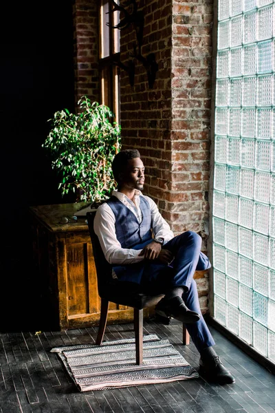 快適ウィンドウの前に座っている彼の仕事について考えて浅黒い肌の青年実業家 — ストック写真