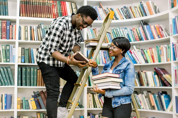 Rahat kıyafetler onun Afro-Amerikan kız öğrenci Kitaplığı'nda adım merdiven üzerinde dururken gerekli bir kitap verilmesi yararlı genç Afro-Amerikan öğrenci
