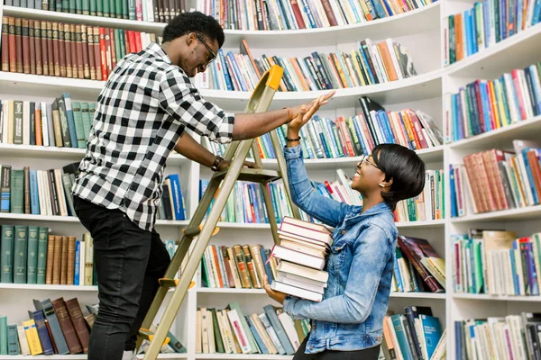 Rahat kıyafetler onun Afro-Amerikan kız öğrenci Kitaplığı'nda adım merdiven üzerinde dururken gerekli bir kitap verilmesi yararlı genç Afro-Amerikan öğrenci