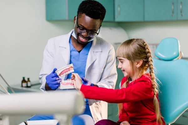 Dentista Africano Mostra Como Escovar Dentes Para Uma Menina Caucasiana — Fotografia de Stock