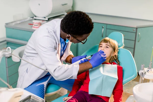 Dentist polishes childs teeth with modern electric tool