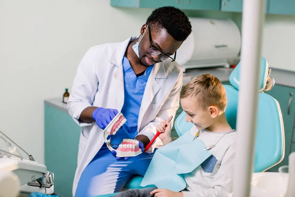 Dentista Africano Mostra Como Escovar Dentes Para Pequeno Menino Caucasiano — Fotografia de Stock