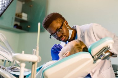 Koltukta oturan dişçi, sevimli gülümseyen çocuk