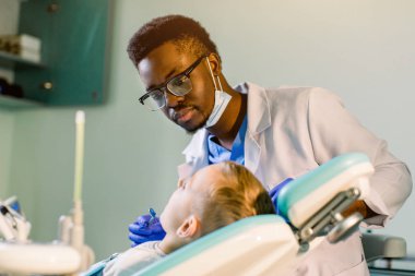 Koltukta oturan dişçi, sevimli gülümseyen çocuk