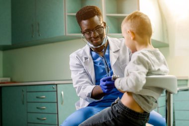Afrikalı Amerikalı doktor ve çocuk hasta. Doktor stetoskop tarafından küçük çocuk inceliyor. Tıp ve Çocuk terapisi kavramı