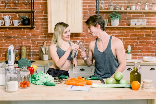 Couple Eating Food Feeding Sweet Concept. A happy couple is preparing food in the kitchen and drinking water