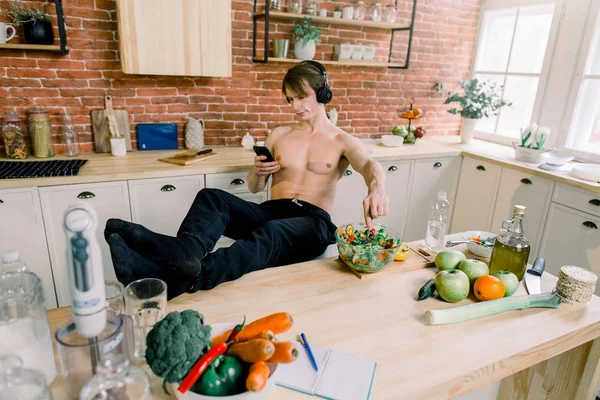 Bonito Homem Cozinhar Casa Preparando Salada Cozinha Jovem Está Ouvindo — Fotografia de Stock