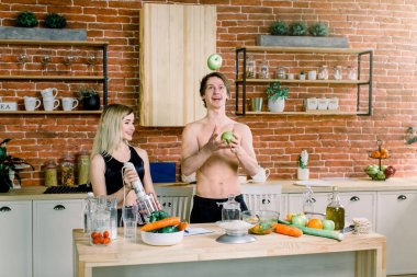 Seven afro Amerikan çift birlikte loft mutfakta yeşil salata hazırlama, çocuk elma atar