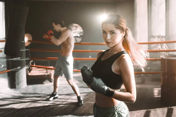 Female boxer doing shadow boxing inside a boxing ring. Boxer practicing her moves at a boxing studio.