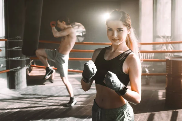Female boxer doing shadow boxing inside a boxing ring. Boxer practicing her moves at a boxing studio.