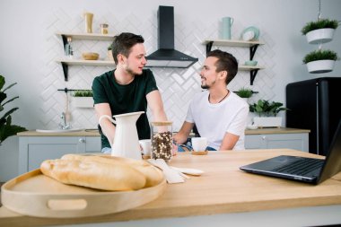 Mutfakta, oturma ve kahvaltı ve kahve yiyorsunuz genç yakışıklı erkekler.