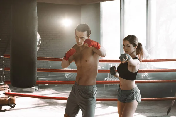 Two sportsmans boxers man and woman wearing boxing gloves on gym background. Sport, box concept.