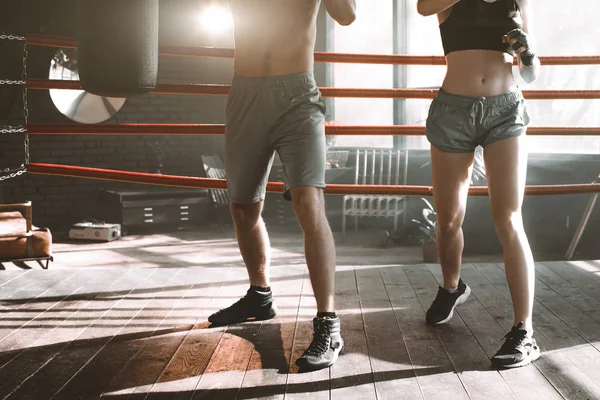 Two sportsmans boxers man and woman wearing boxing gloves on gym background. Sport, box concept.