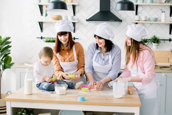 Due sorelle, nonna e bambina cucinano in cucina alla festa della mamma, serie di foto di stile di vita in interni luminosi — Foto Stock