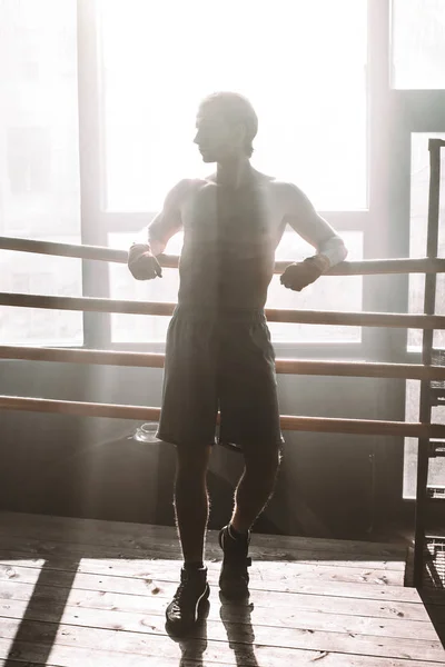 Retrato de boxeador deportivo con vendajes de boxeo en las manos mientras descansa después del entrenamiento en el gimnasio — Foto de Stock