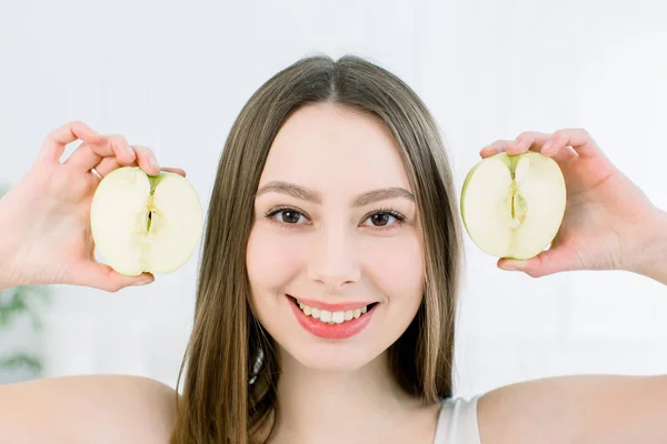 Hermoso retrato de cerca de una joven con mitades de manzana. Concepto de comida saludable. Cuidado de la piel y belleza. Vitaminas y minerales . —  Fotos de Stock