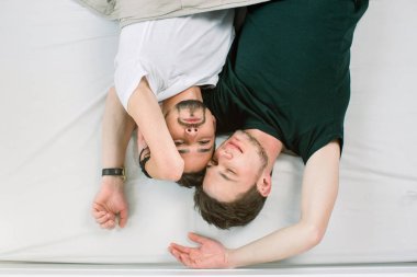 Genç gay çift yatakta, üstten görünüm yatıyordu. Sevgililer günü. İki seksi adam yatakta.