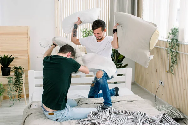 Potret pasangan gay muda bertengkar bantal di kamar tidur — Stok Foto