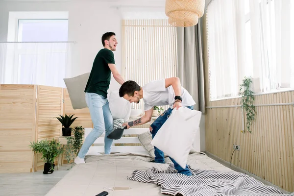 Pasangan gay berkelahi bersama dengan bantal di tempat tidur — Stok Foto