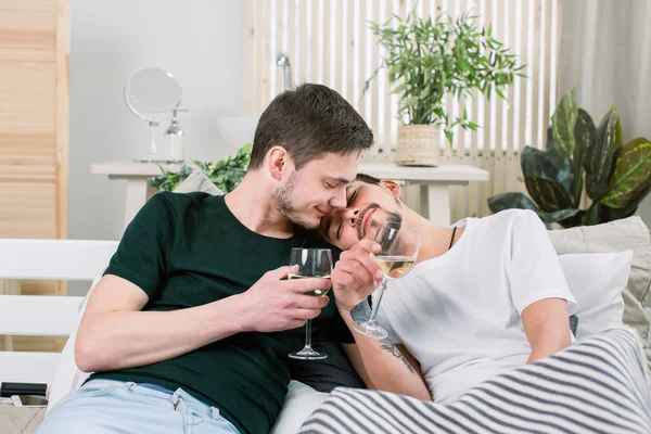 Europeu feliz gay casal beber vinho enquanto se divertindo na cama, acariciando. Relações homossexuais e conceito alternativo de estilo de vida amoroso — Fotografia de Stock