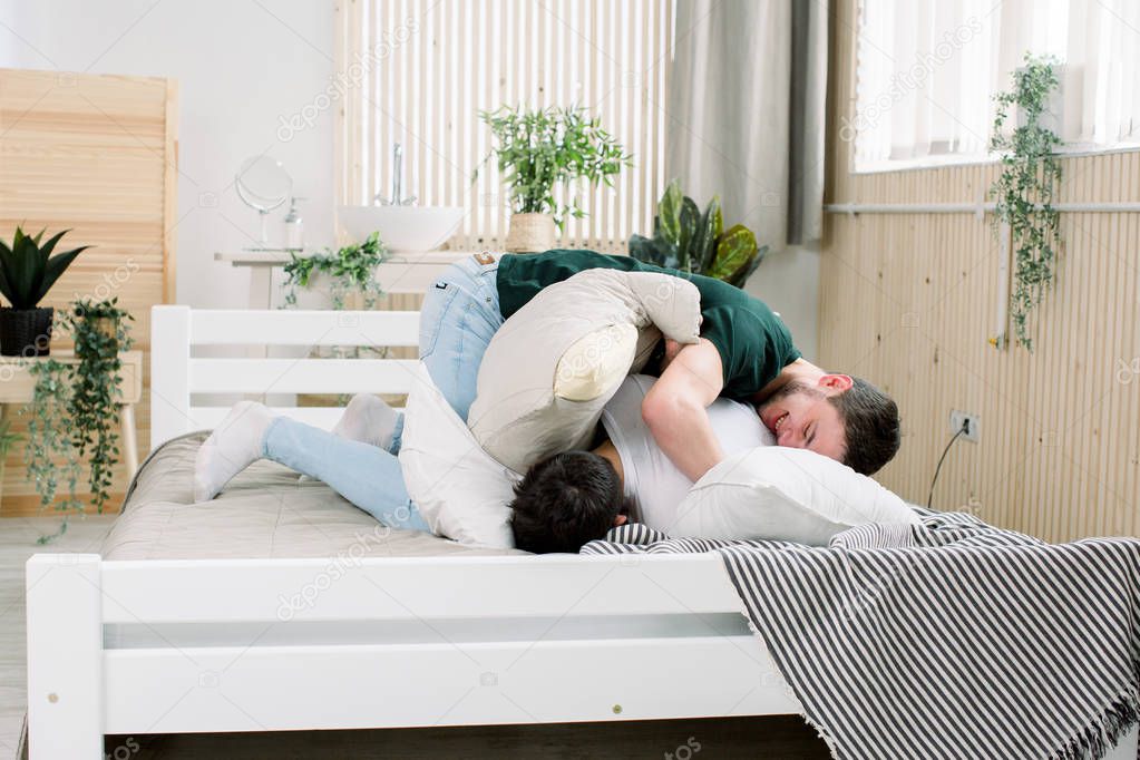 Picture showing happy gay couple having pillow fight