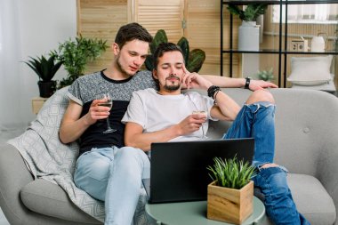 Mutlu gay çift kanepede oturan, film izlerken ve şarap içme. Gay çift, homoseksüel kavramı