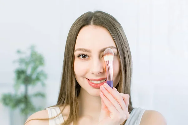 Portrait of beautiful young Caucasian woman with clean face. Beauty spa model girl with perfect fresh clean skin applying cosmetic brush. Youth and skin care concept. — Φωτογραφία Αρχείου