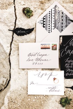Düğün davetiye kağıtları rustik, Boho tarzı, kum üzerinde döşeme, yaprakları Ile süsleyin, succulents. Düğün daveti kartları, el sanatları zarfları. Tepe görünümü. Düz yatıyordu, üst görünüm