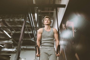 Fitness adam spor salonunda halka yapışmaları. Sağlıklı yaşam tarzı, spor salonunda adam eğitimi.