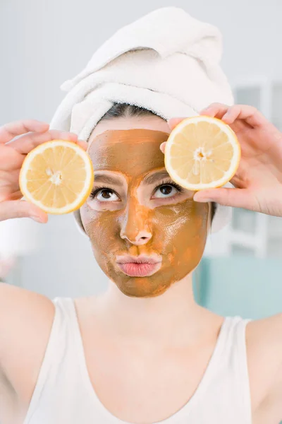 Ung frisk kvinna i spa gör behandlingar och ansikte lera mask. — Stockfoto