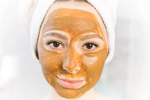 Kosmetik coklat masker tanah liat pada wajah cantik perempuan muda, terisolasi di atas putih — Stok Foto