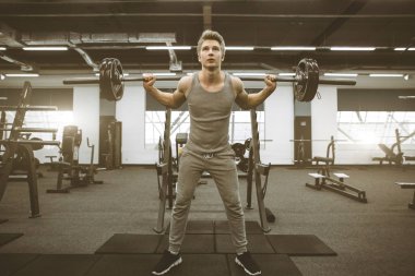 Spor salonunda ağırlık kaldıran fit ve yırtık adam. Jimnastik yaşam tarzı kavramı.