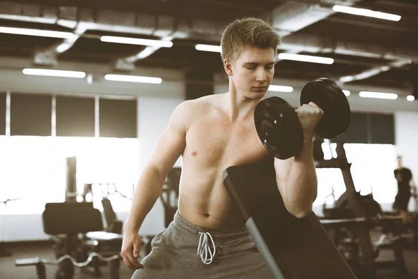 Fechar-se de um homem de aptidão de força com halteres, tendo treino no ginásio. Encaixe jovem com belo tronco. Iniciante fisiculturista e conceito de corpo muscular . — Fotografia de Stock