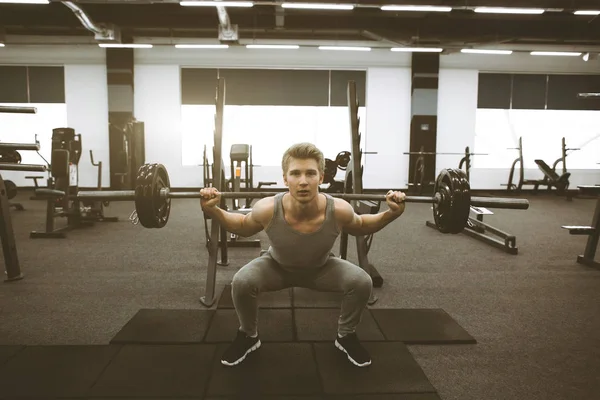 Knappe man in goede fysieke conditie met spieren in de sportschool training met barbell — Stockfoto