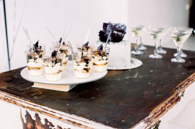 Parti kutlama konsepti, yemek ve tatlılar. Vintage ahşap masada lezzetli doğum günü pastası, tiramisu tatlılar ve alkollü içecekler