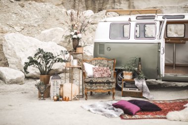 Yeşil hippi otobüs, yastık, retro radyo, bitkiler, sulu, çiçek ve mumlar, çöl manzara arka planda kürk halı ile altın metal süslemeleri ile vintage koltuk. Boho dekoru