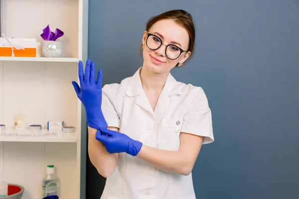 portrait of smiling beautiful woman doctor wearing gloves. medical employee. Cosmetologist before anti ageing procedure for her client. Aesthetic medicine, skin care and cosmetology.