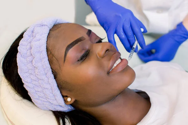Пластична хірургія. Молода Африканська жінка отримує косметичне ін'єкції в губи. Вид збоку красива Африканська жінка рішень краси ін'єкції для губ — стокове фото