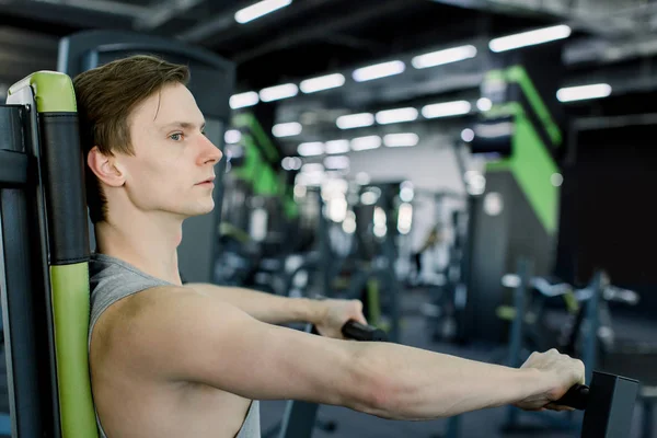 Handsome muscular man working out hard at gym. Biceps, triceps, exercises. Chest workouts.