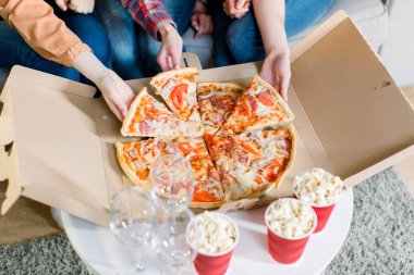 Pizza yiyen kadın arkadaşların elleri. Evde parti yapıyorlar, pizza yiyorlar ve eğleniyorlar. eğlence, yiyecek ve içecek, insanlar ve tatil kavramı