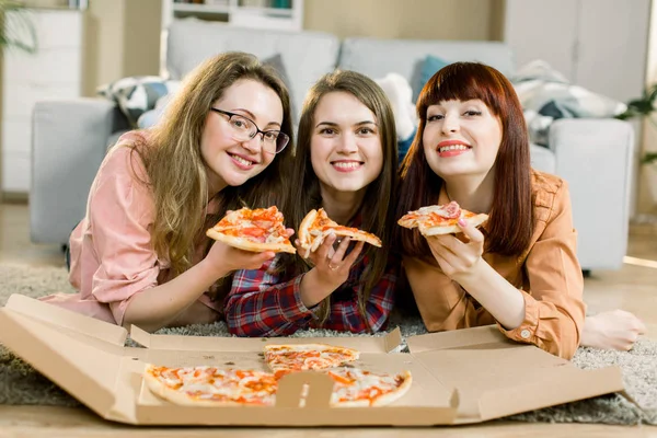 Persahabatan, orang, pesta rumah dan konsep makanan menutup dari tiga cukup bahagia teman perempuan atau gadis makan pizza di rumah — Stok Foto