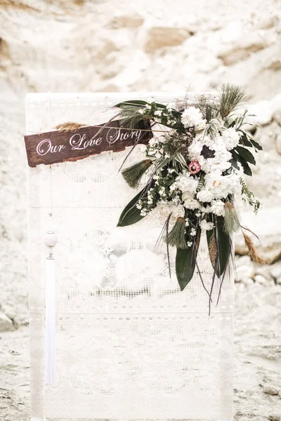 Romantic rustic wedding ceremony in desert. wooden arch with white cloth and flowers. Boho wedding ceremony