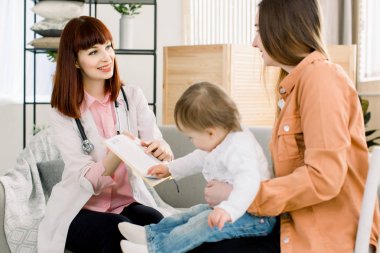 Genç anne ve bebeği için tedavi açıklayan güzel çocuk doktoru Portresi, doktorlar evde ziyaret
