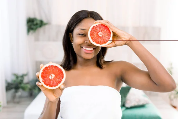 Szépség afrikai nő narancsos citrus grapefruit az egészséges bőrtest. Vonzó friss vitamin. Stúdiófelvétel. — Stock Fotó